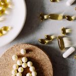 Variety of capsules and pills arranged on a marble surface. Healthcare and medicine theme.
