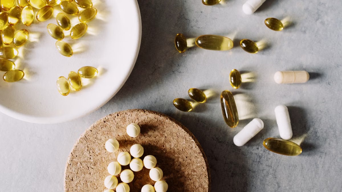 Variety of capsules and pills arranged on a marble surface. Healthcare and medicine theme.